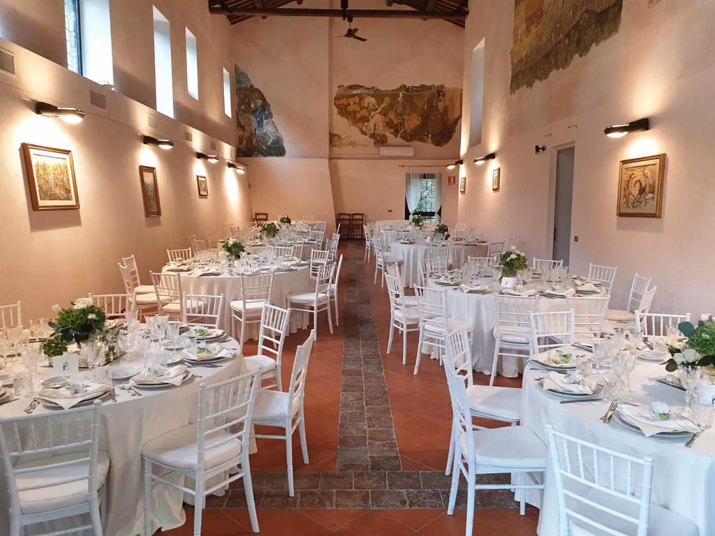 La sala interna dell'abbazia con i tavoli apparecchiati per il ricevimento